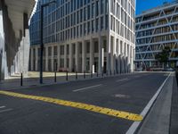 the empty street with bicycles parked in front of the buildings has a sign that says the library on it