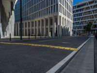 the empty street with bicycles parked in front of the buildings has a sign that says the library on it