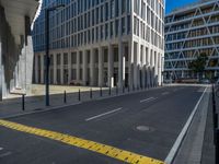 the empty street with bicycles parked in front of the buildings has a sign that says the library on it