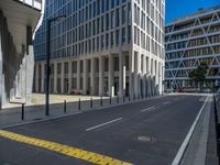 the empty street with bicycles parked in front of the buildings has a sign that says the library on it