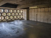 the large room has several windows in it and lots of concrete floors with wood furniture and round window