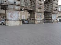 there is a car that is parked in front of a building that has a stair case and cars around it