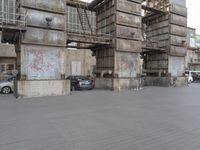 there is a car that is parked in front of a building that has a stair case and cars around it
