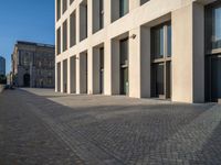 an empty sidewalk near buildings in a city area of europe, in front of blue sky