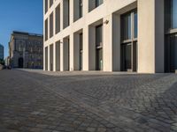 an empty sidewalk near buildings in a city area of europe, in front of blue sky