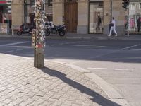 a street corner with an odd parking meter in it's front corner and people in the background