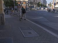 two men walking down the street beside a parking lot with bike racks on both sides of the road