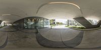 a round view of an entrance, with a curved concrete walkway in front of it