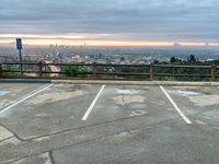 a photo of an empty parking lot and a city skyline from the distance, with clouds overhead