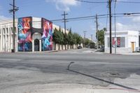 the intersection in an urban setting with a building and street art on the corner,