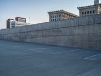 several large empty parking spaces in the city with buildings nearby in front of them -