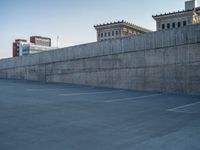 several large empty parking spaces in the city with buildings nearby in front of them -