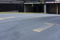 a skateboard sitting on top of an empty parking lot near some tall buildings and yellow lines