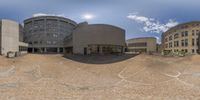 some buildings in an open air area with a circular glass window view of some buildings