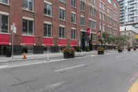 a city street next to two large buildings in a city intersection with no sidewalks on the streets