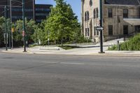 two cars driving down the road while some buildings look on in the distance or city