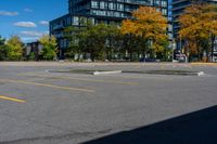 a fire hydrant sitting in front of two tall buildings with trees surrounding it with yellow paint on the pavement