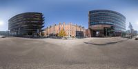 a circular mirror in a parking lot in an urban setting in front of some buildings