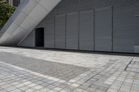 a walkway between two brick tiles and a gate outside a building with open bars on the walls