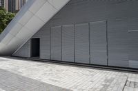 a walkway between two brick tiles and a gate outside a building with open bars on the walls
