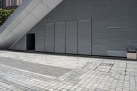 a walkway between two brick tiles and a gate outside a building with open bars on the walls