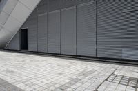 a walkway between two brick tiles and a gate outside a building with open bars on the walls
