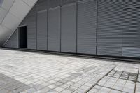 a walkway between two brick tiles and a gate outside a building with open bars on the walls