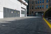 a street lined with parked cars in front of some buildings, which have metal shutters