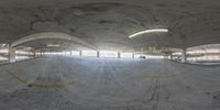 a skateboarder riding a ramp at a skate park that is surrounded by concrete pillars