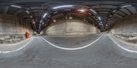 a fish - eye view of a skate park in the middle of a tunnel with ramps and a ramp and concrete walls