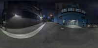 a skate boarder is doing stunts at night near a building and street lights in the dark