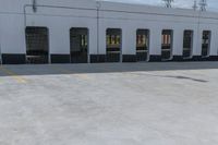 a man is riding a skateboard by an empty building on the road by some electrical wires