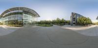 a skateboard park with a skateboard ramp and ramps in front of a glass building