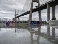 this is an urban skate park with graffiti painted on it's concrete ground and a bridge in the background