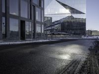 a person skates past a large glass building in the distance between two other buildings