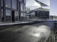 a person skates past a large glass building in the distance between two other buildings