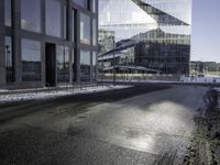 a person skates past a large glass building in the distance between two other buildings