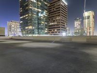 a night scene showing a building and some cars going down a highway next to tall buildings