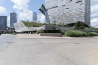 an empty parking lot has stairs in it's center with city buildings beyond it