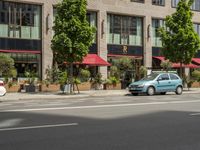 the car is parked on the side of the street beside the store's canopy