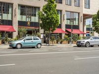 the car is parked on the side of the street beside the store's canopy