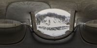 a photo of an arched wall with a snow covered ground in the background and there is a ramp going through it