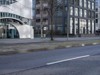 a very modern office building in a city setting with its curved facade that provides the opportunity for pedestrians to enter
