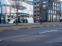 a very modern office building in a city setting with its curved facade that provides the opportunity for pedestrians to enter