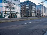 a very modern office building in a city setting with its curved facade that provides the opportunity for pedestrians to enter