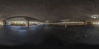 the empty parking garage is empty for this man to use while he rides on his skateboard