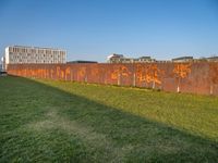 this grass field has been cut short to cover the area in the distance, and it is a grassy area next to an old building