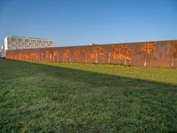 this grass field has been cut short to cover the area in the distance, and it is a grassy area next to an old building