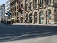 a street is empty and full of people walking and riding bikes nearby buildings and a street light