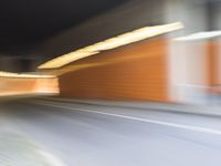 an abstract photo of a person riding down the street while a car is coming up and out